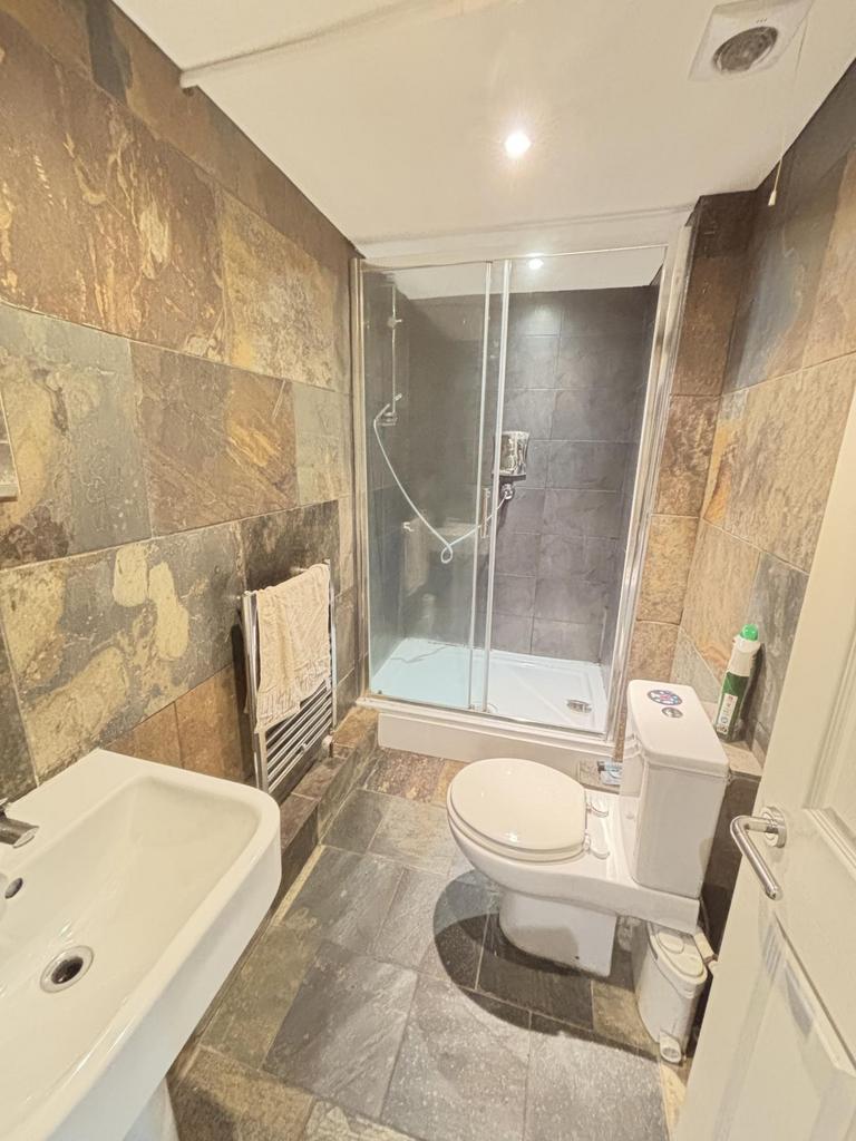 A modern bathroom featuring a shower enclosure,...