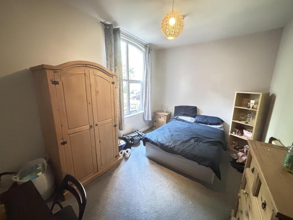 A cozy single bedroom featuring a double bed, a...