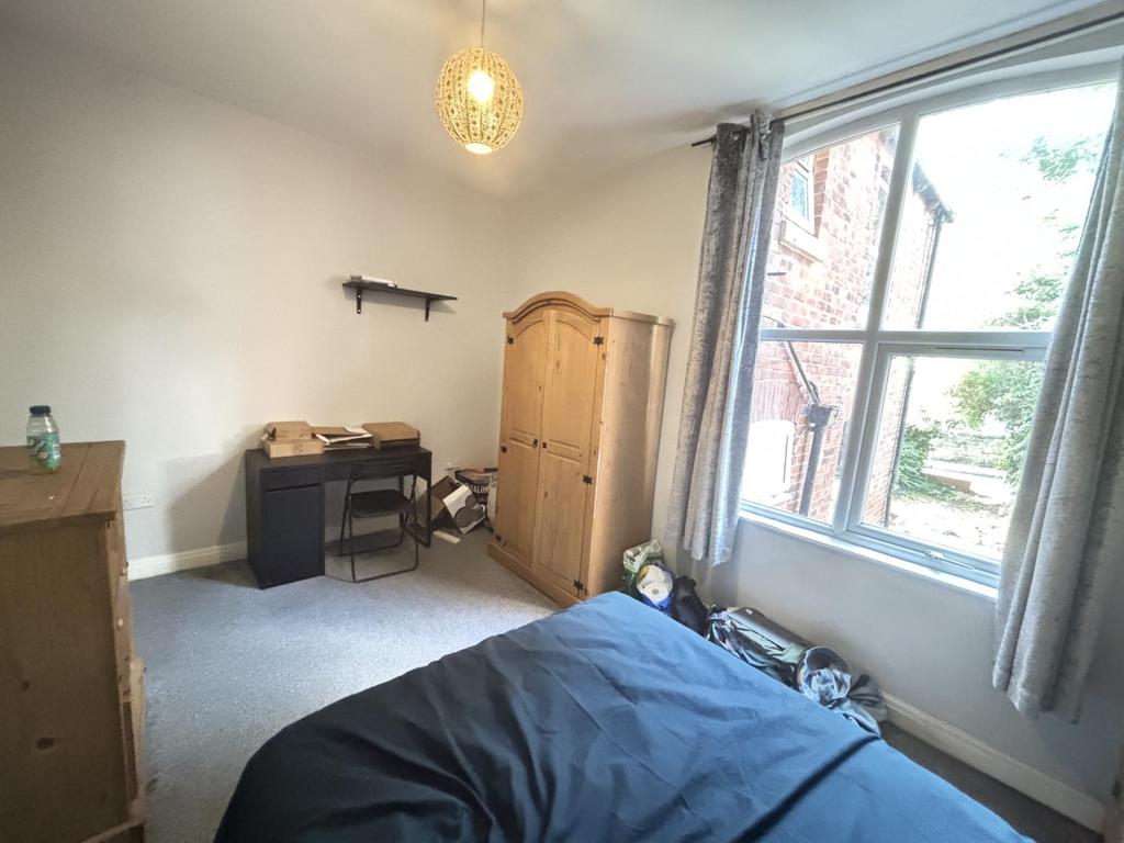 A cozy bedroom with a single bed, a wooden ward...