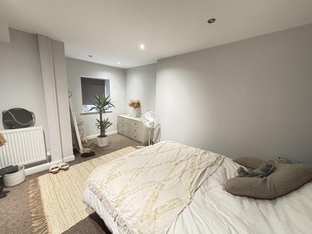 A bright and cozy bedroom featuring a comfortab...