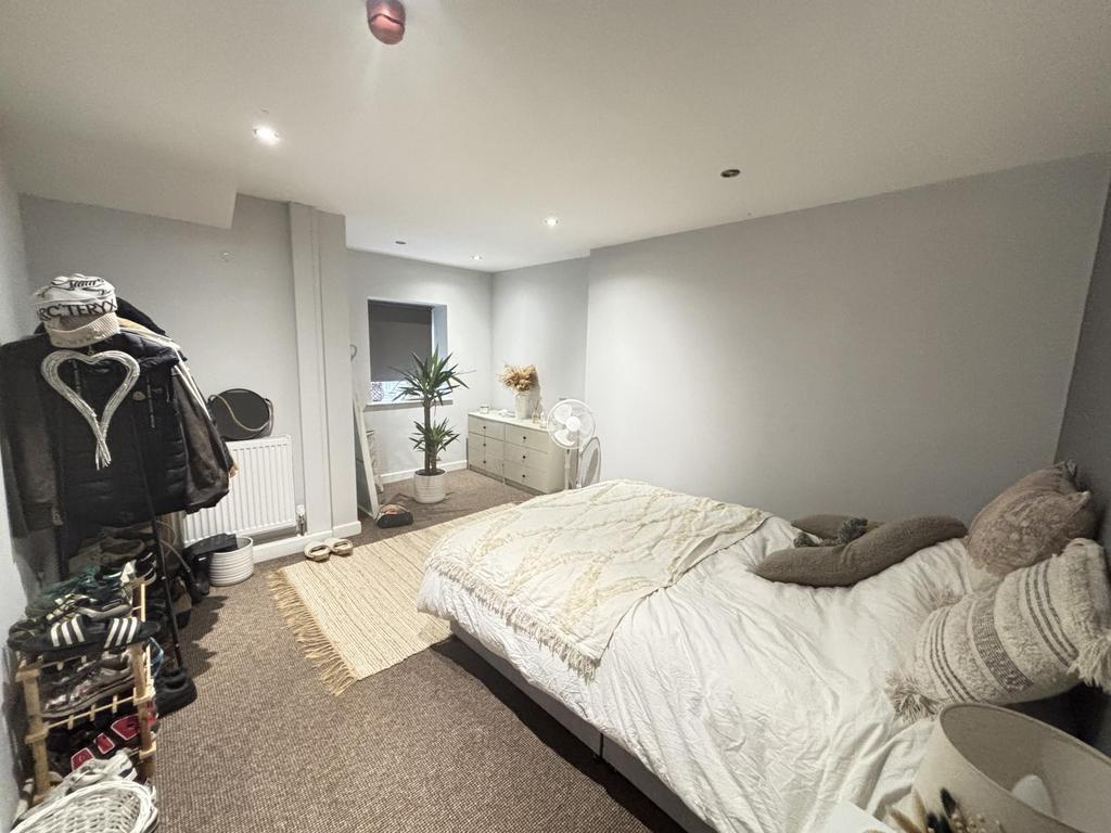 A spacious and well-lit master bedroom featurin...