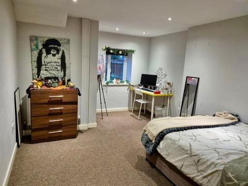 A cozy bedroom with a single bed, ample natural...