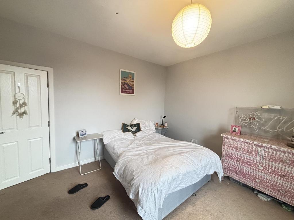 A cozy single bedroom featuring a neatly made b...