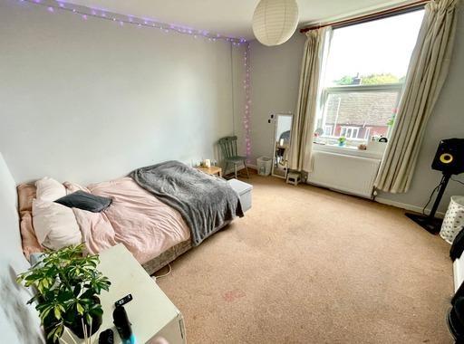 A bright and inviting bedroom featuring a spaci...