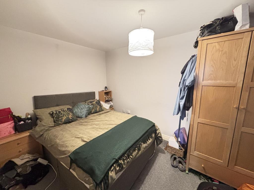 A cozy bedroom featuring a double bed with a he...