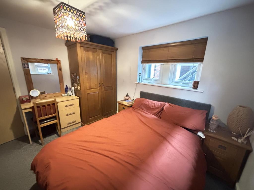 A cozy bedroom featuring a double bed with pink...