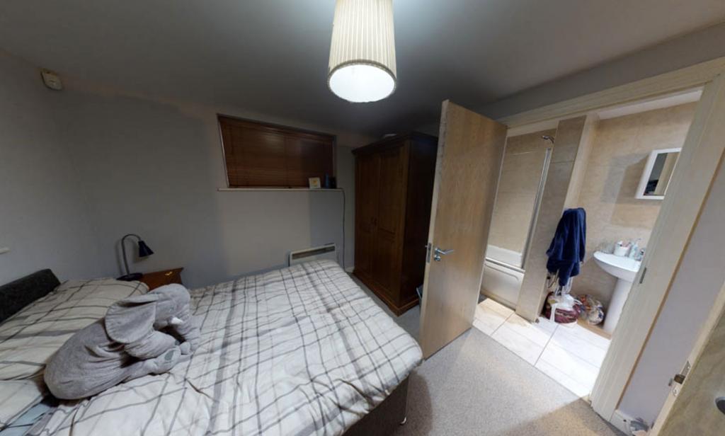 A well-lit, tidy bedroom with a large double be...