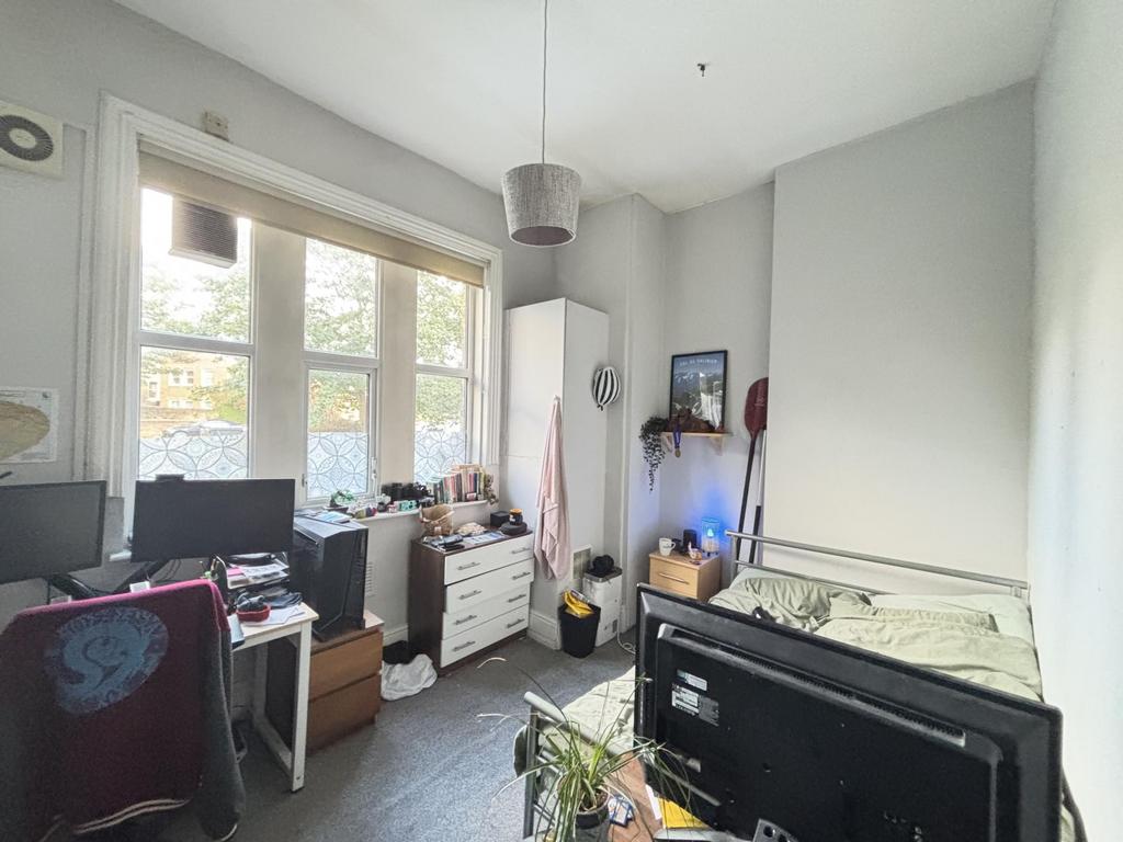 The bedroom features a comfortable bed, a desk ...