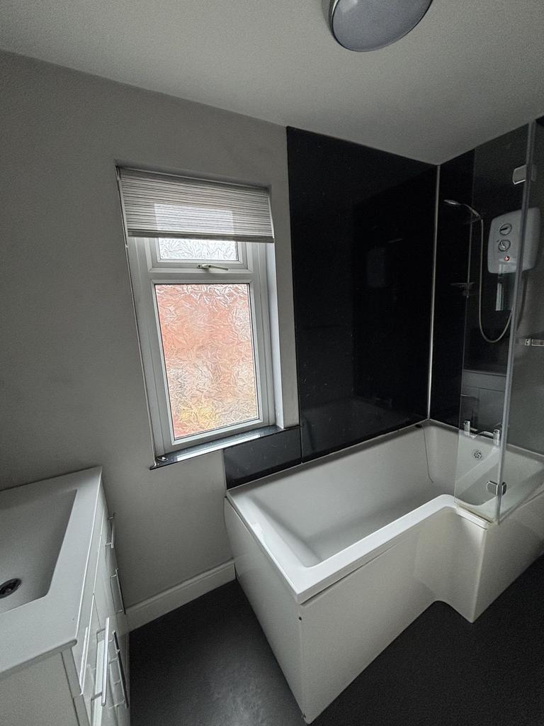 A modern, bright bathroom featuring a large bat...