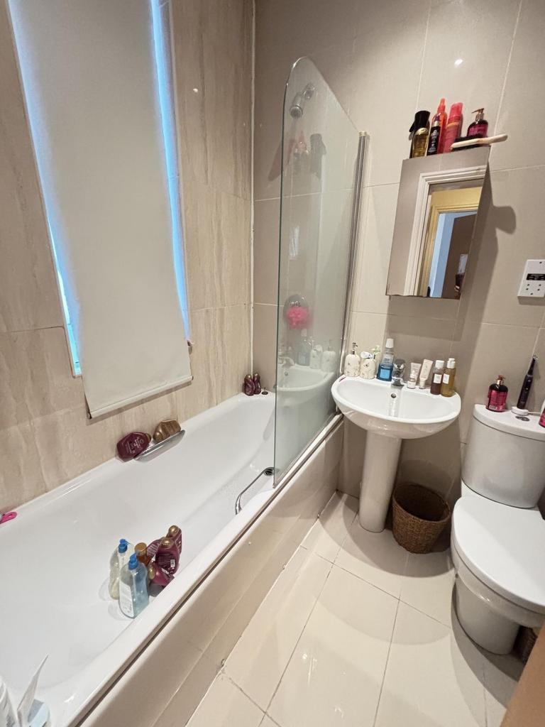 A clean and modern bathroom featuring a bathtub...
