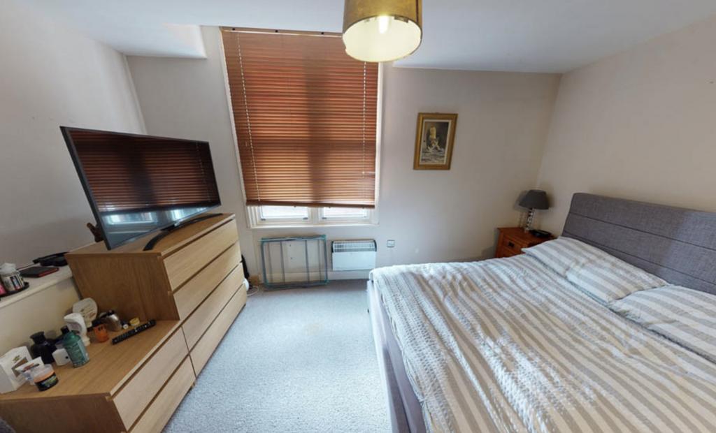 A well-lit and tidy bedroom featuring a double ...