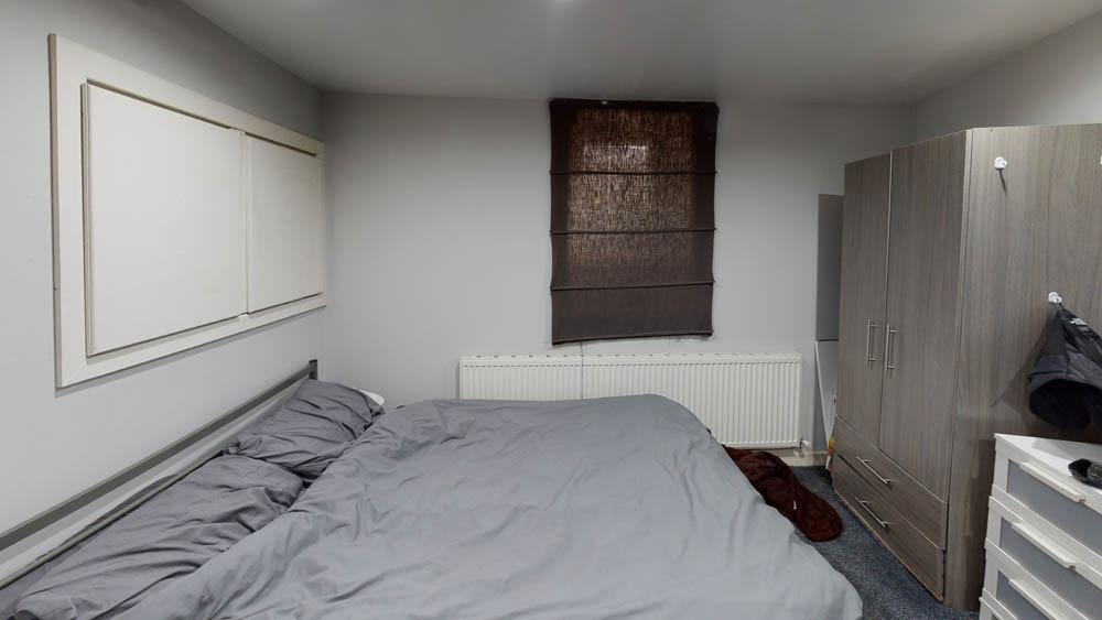 A cozy bedroom featuring a double bed and a war...