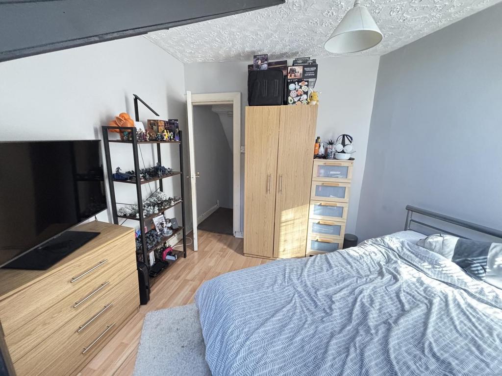 A bright and tidy bedroom featuring a comfortab...
