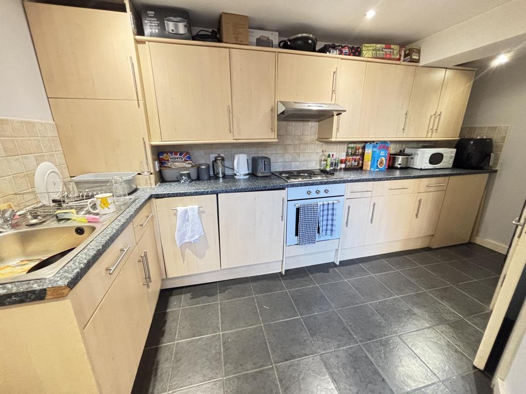 Bright fitted kitchen with light wood cabinets,...