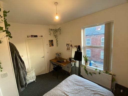 A cozy bedroom with a large window allowing nat...