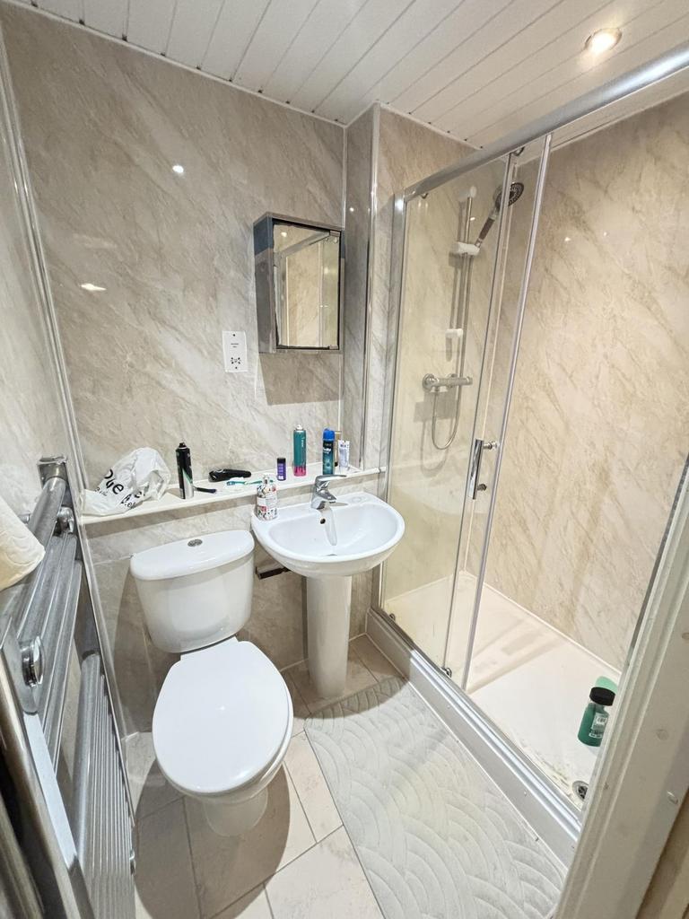 Modern bathroom featuring a spacious shower enc...