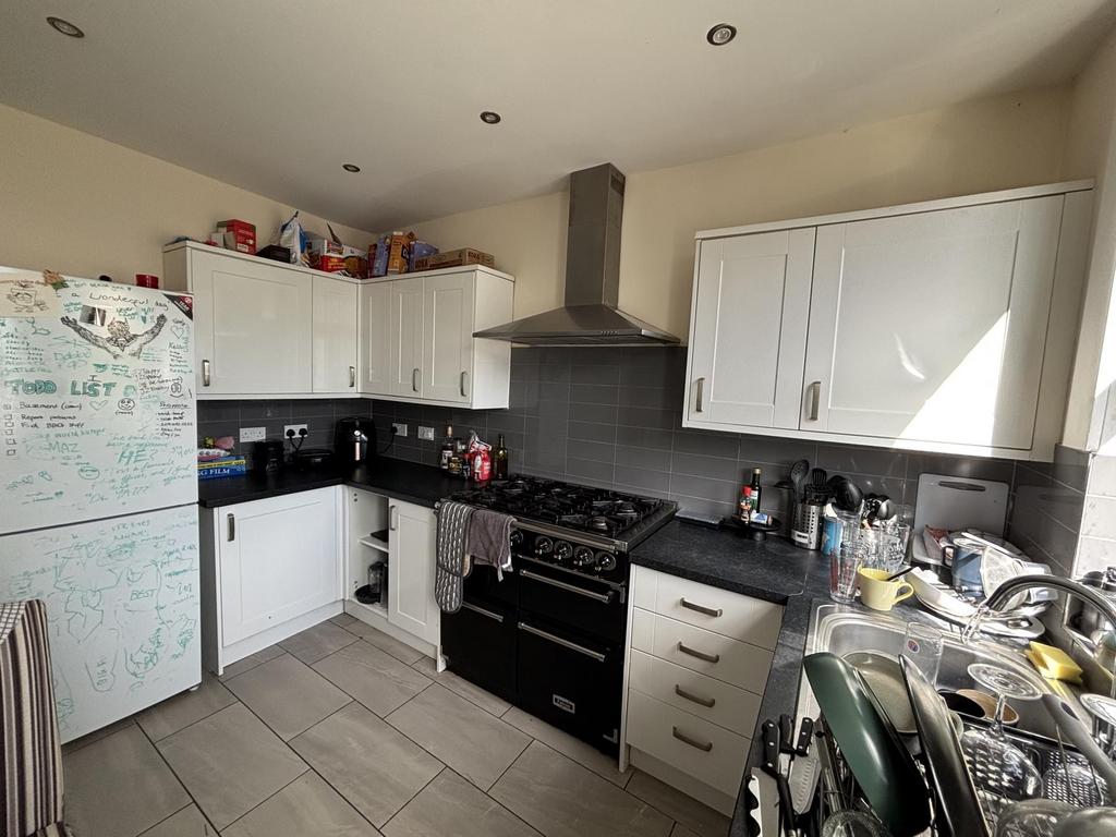 A modern kitchen with white cabinets, a black c...