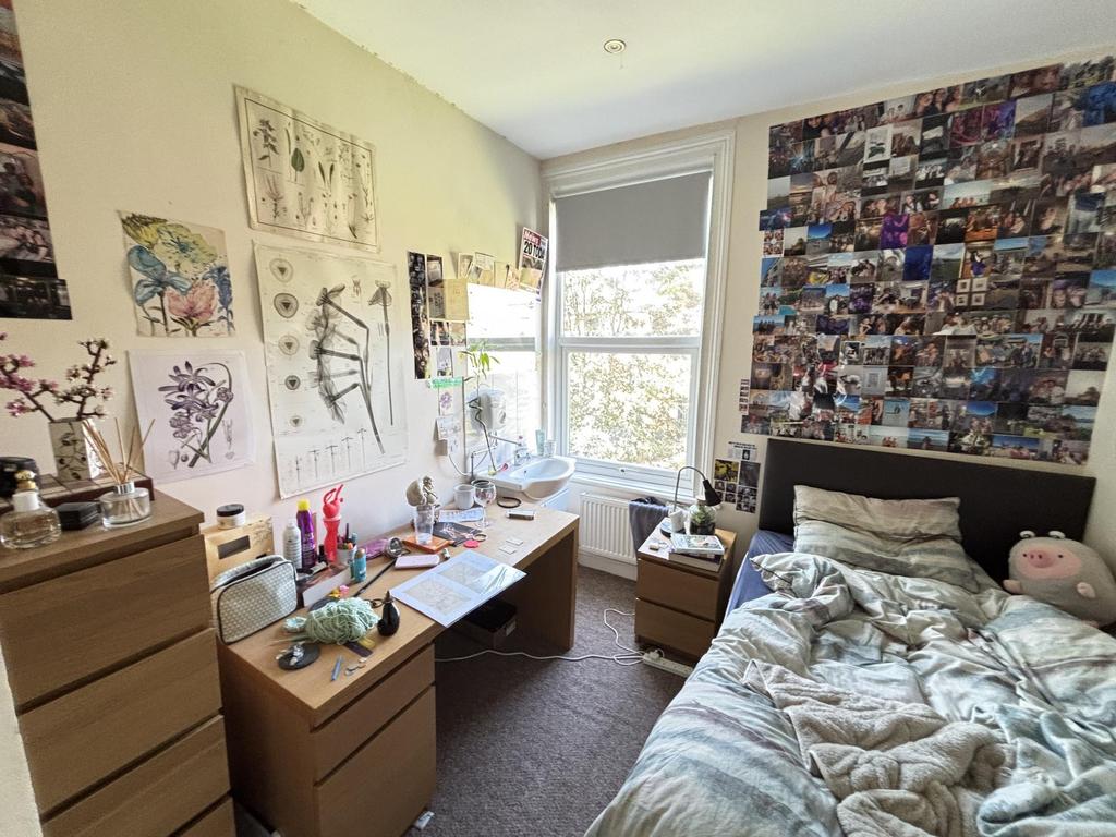 A spacious and well-lit bedroom featuring a lar...