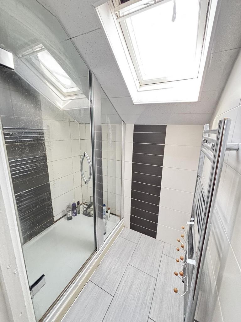 A bright and clean bathroom with a large bath, ...