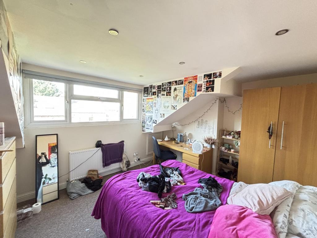 A spacious and well-lit master bedroom featurin...
