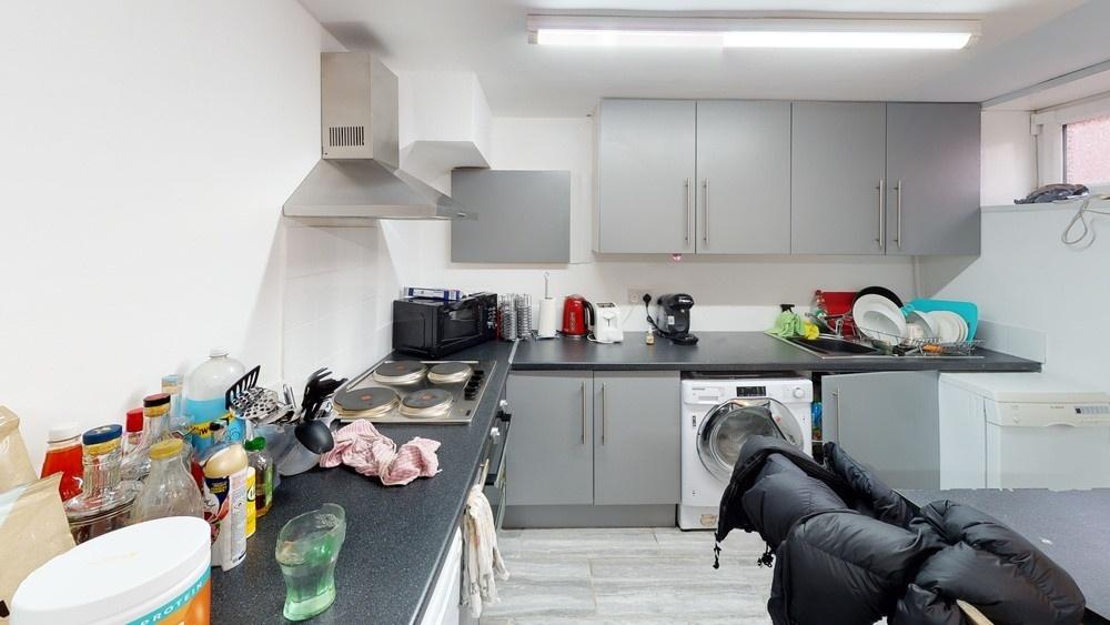 Modern and well-lit kitchen area with ample wor...
