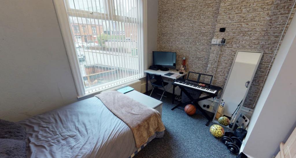 A cozy bedroom featuring a single bed next to a...