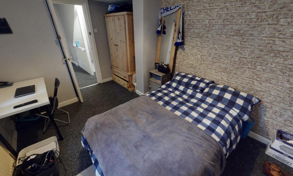 A cozy double bedroom with a neatly made bed fe...