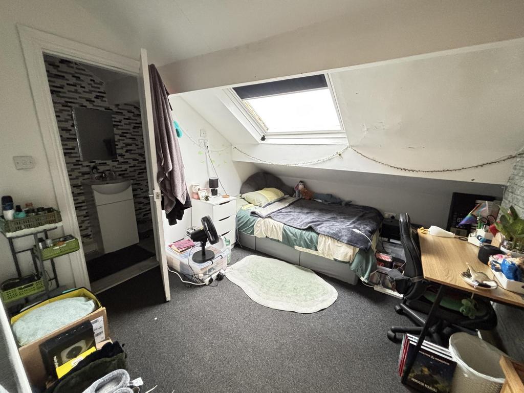 A cozy bedroom with a single bed positioned ben...