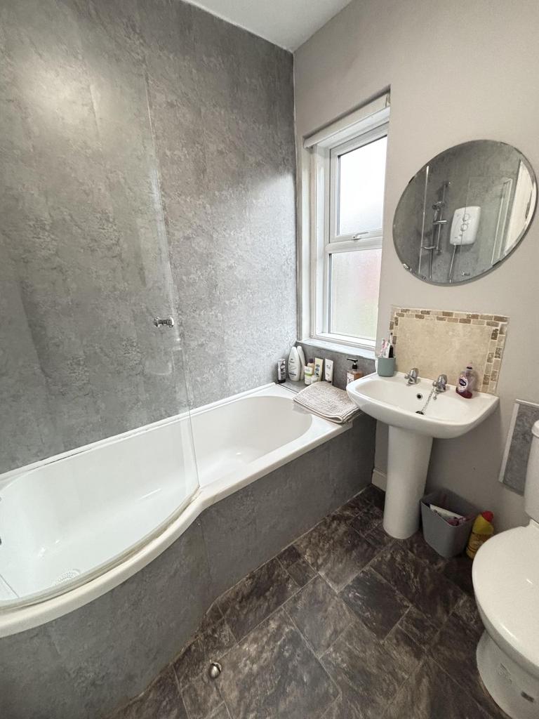 A modern bathroom featuring a bathtub with a sh...