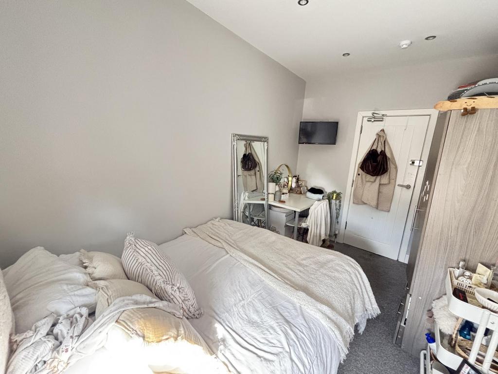 A bright and inviting bedroom featuring a comfo...