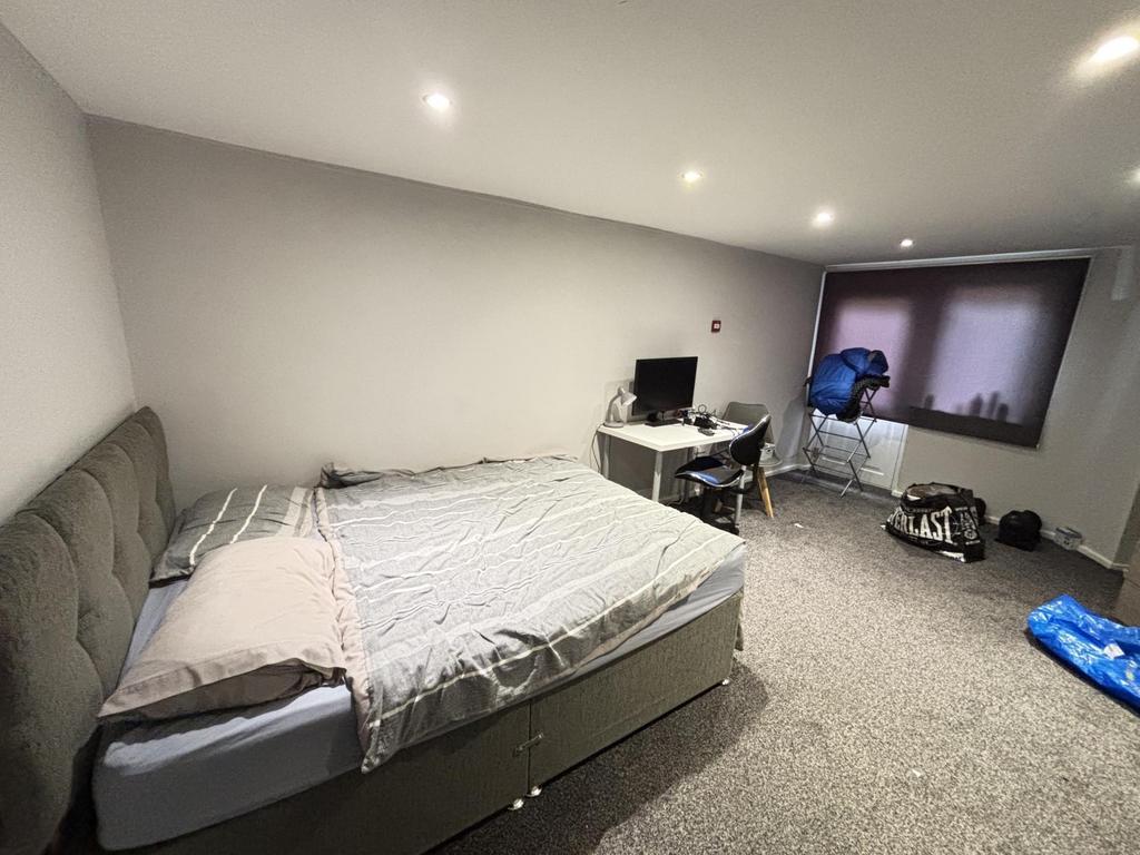 A spacious master bedroom featuring a large bed...
