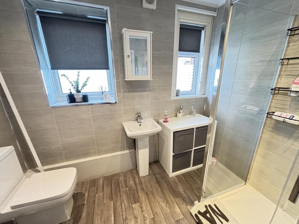 A clean and bright bathroom with a modern showe...