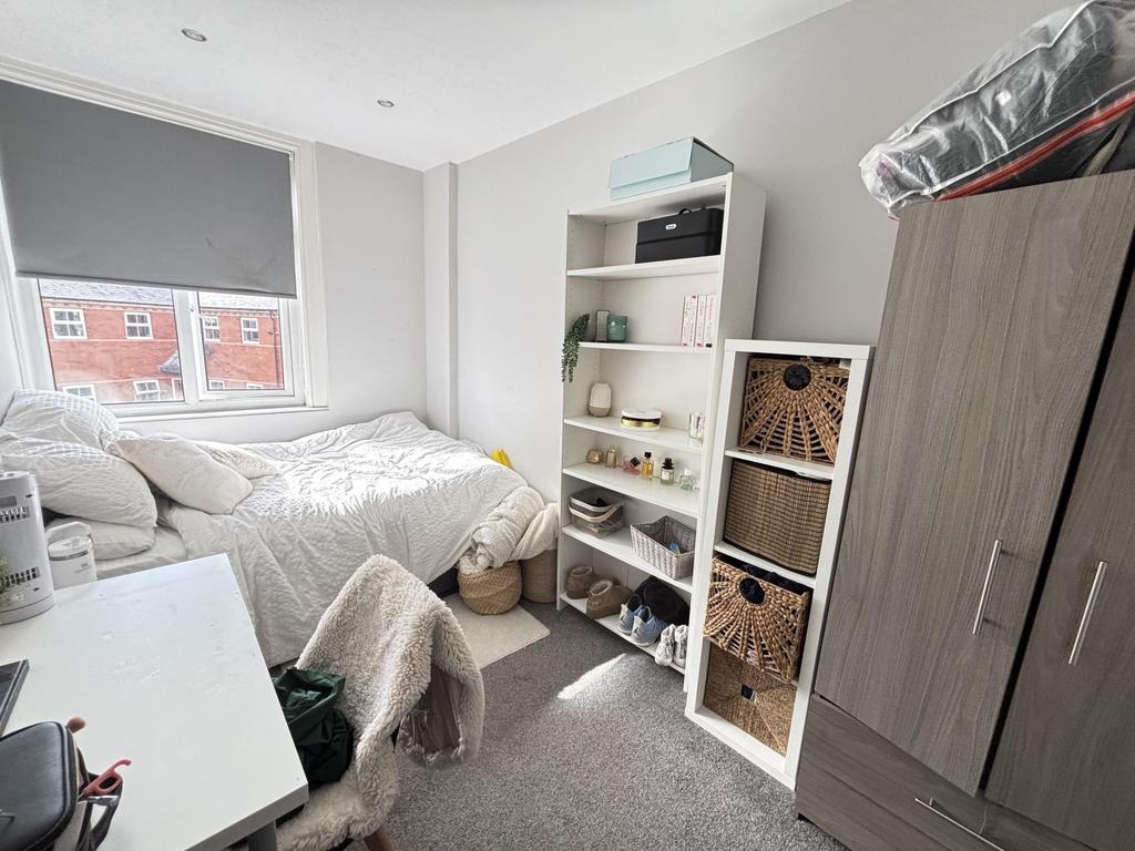 A bright and tidy bedroom with a comfortable be...