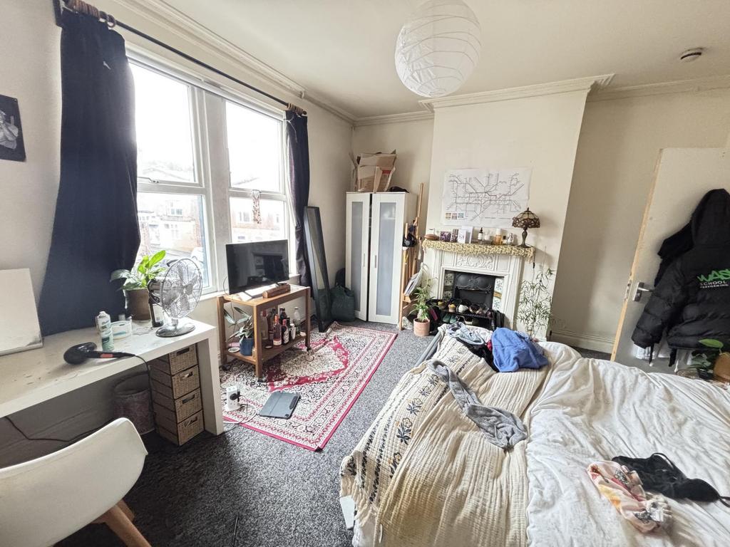 A cozy bedroom featuring a large window with na...