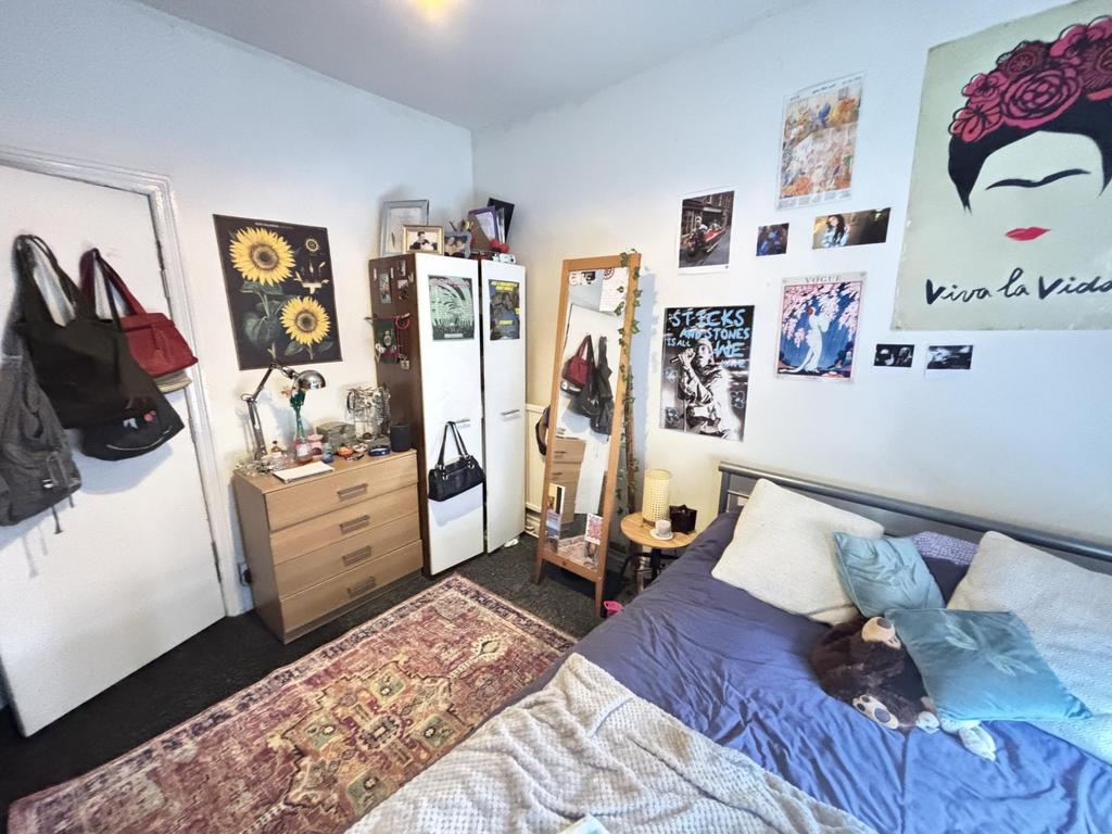 A cozy bedroom featuring a bed with pillows and...