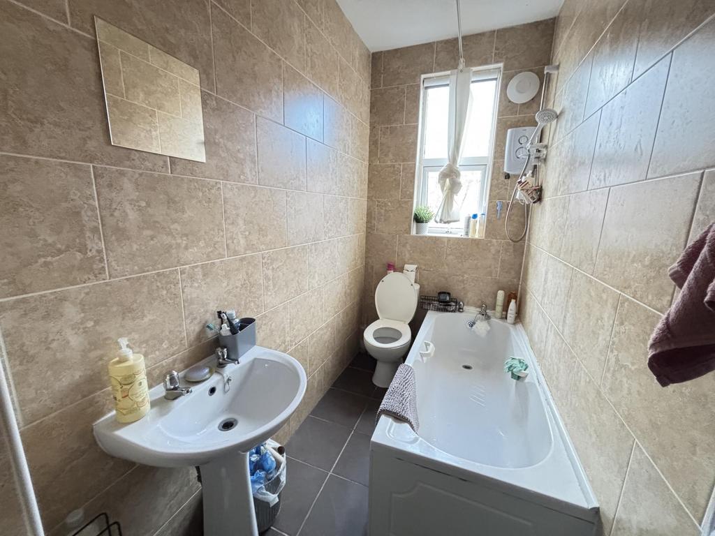 A well-maintained bathroom with a large bathtub...