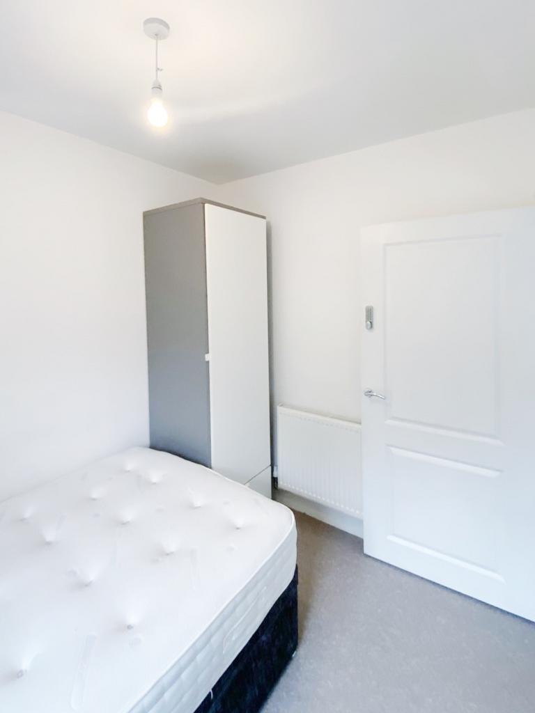 Bright, simply furnished bedroom with a comfort...