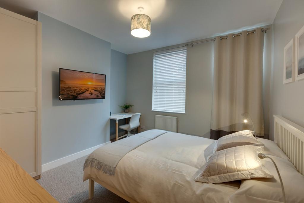 A bright and tidy bedroom featuring a comfortab...