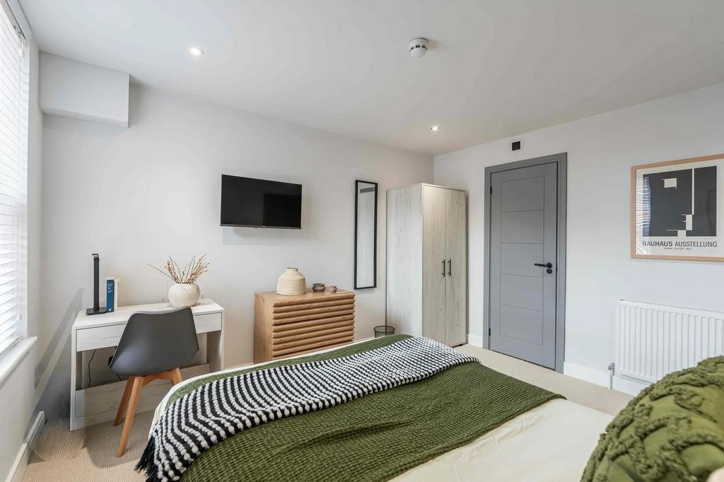 A bright and cozy double bedroom featuring a co...