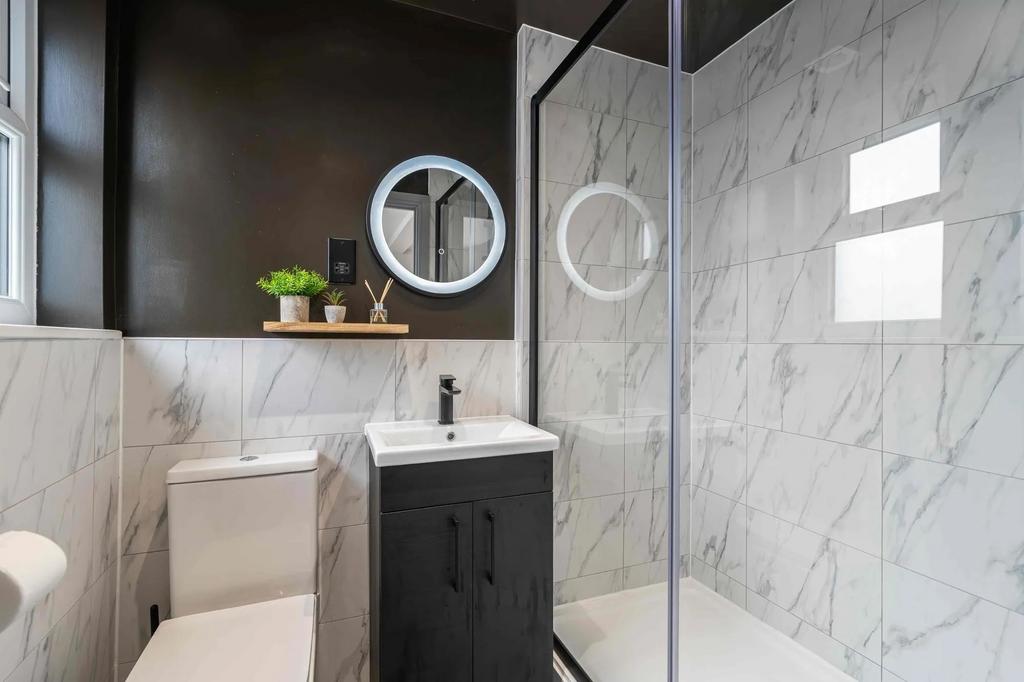 Modern, sleek bathroom featuring a large walk-i...
