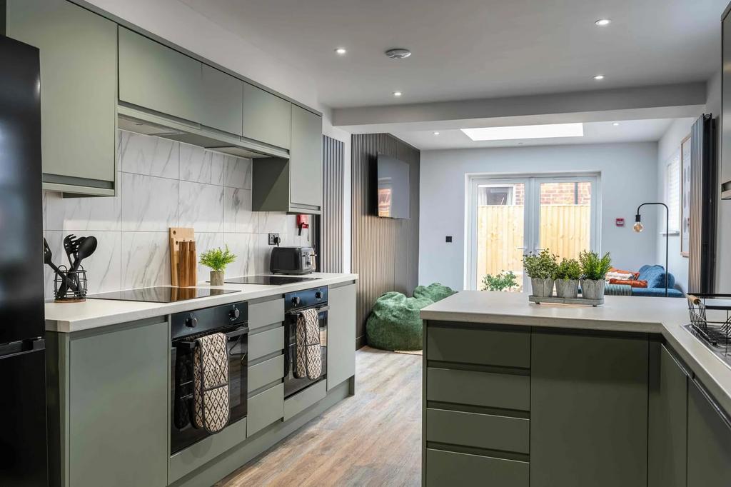 Modern and stylish kitchen featuring sleek gree...