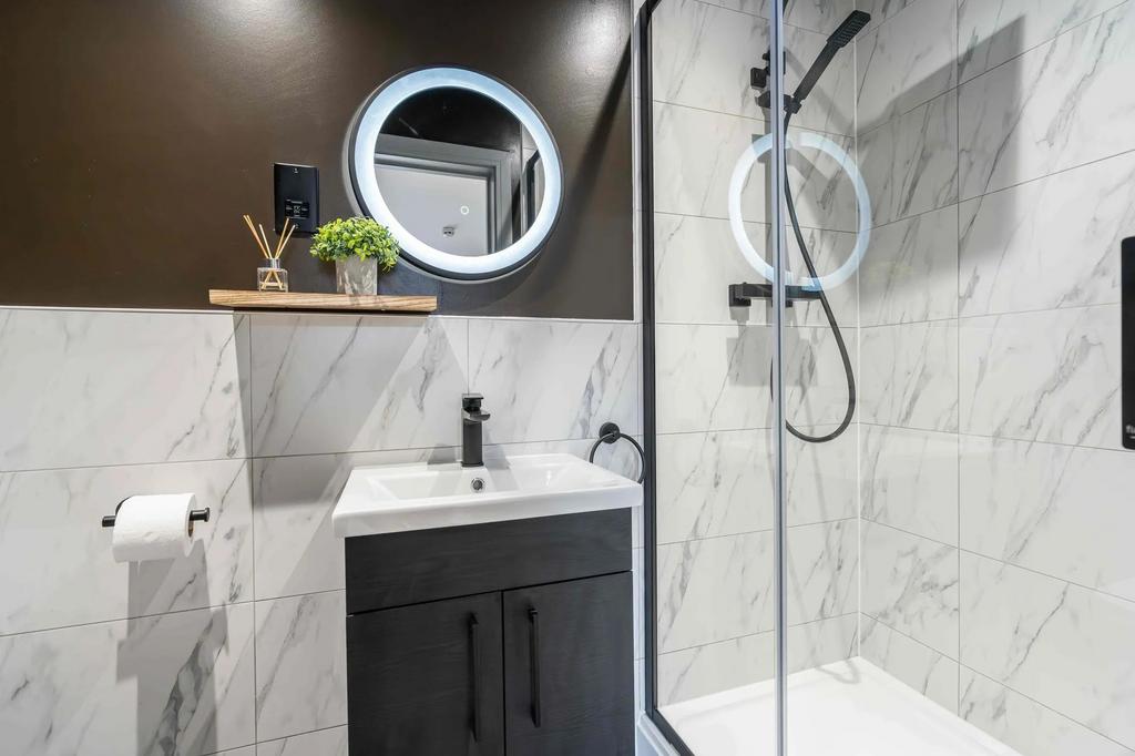 Modern and sleek bathroom featuring a walk-in s...