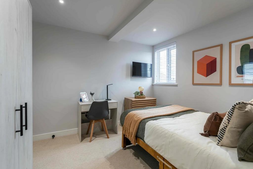 A modern, well-lit bedroom with a comfortable b...