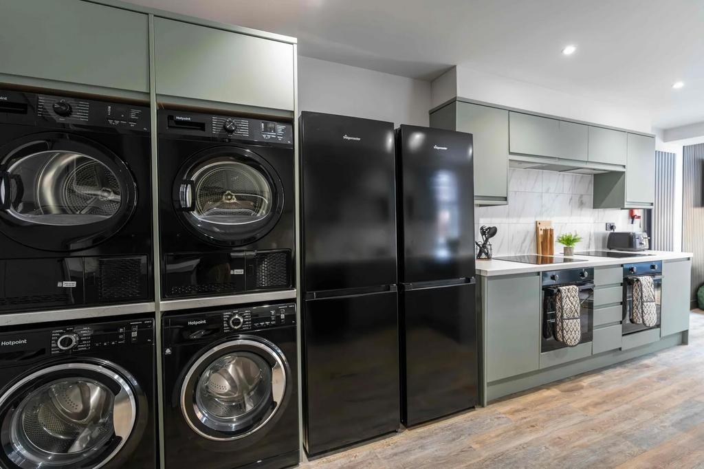 Modern kitchen featuring sleek green cabinets, ...