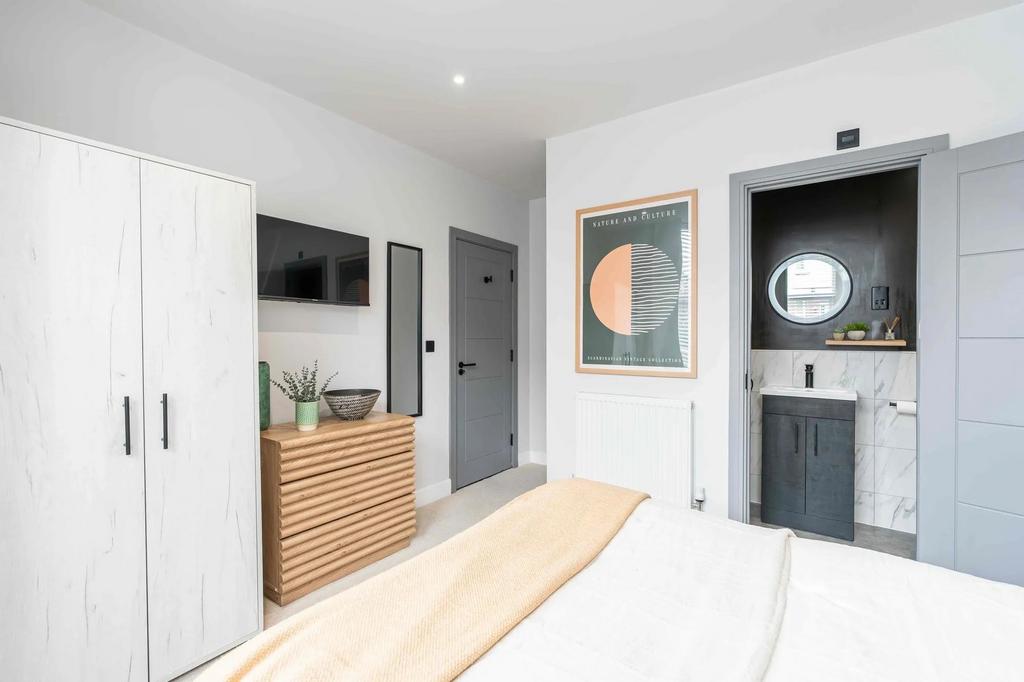 Bright and modern master bedroom featuring ampl...