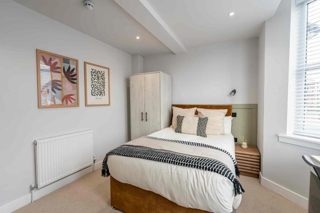 A bright and modern bedroom featuring a double ...
