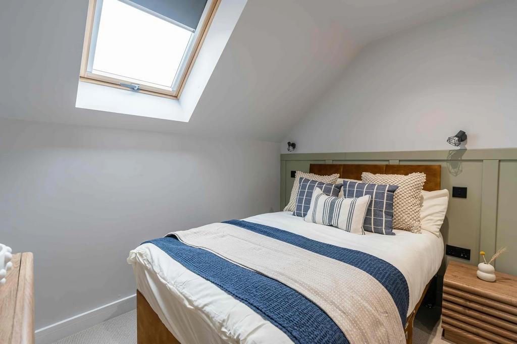 Bright and inviting master bedroom with skyligh...