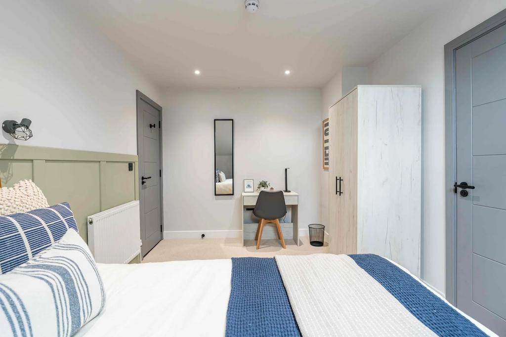 Bright and modern master bedroom featuring a do...
