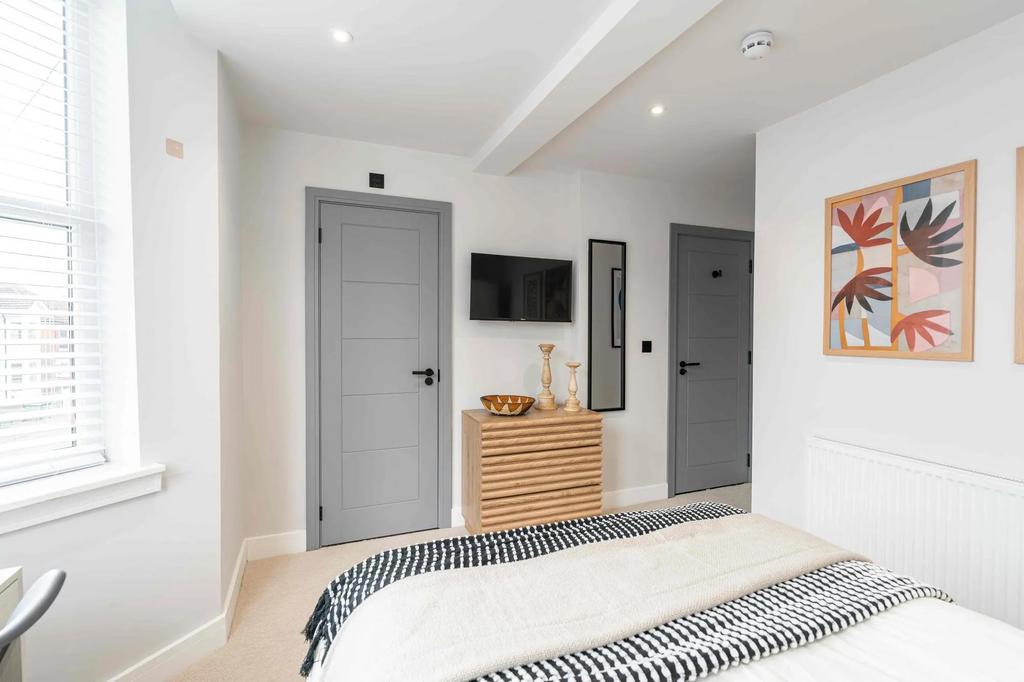 Bright and modern master bedroom featuring a sp...