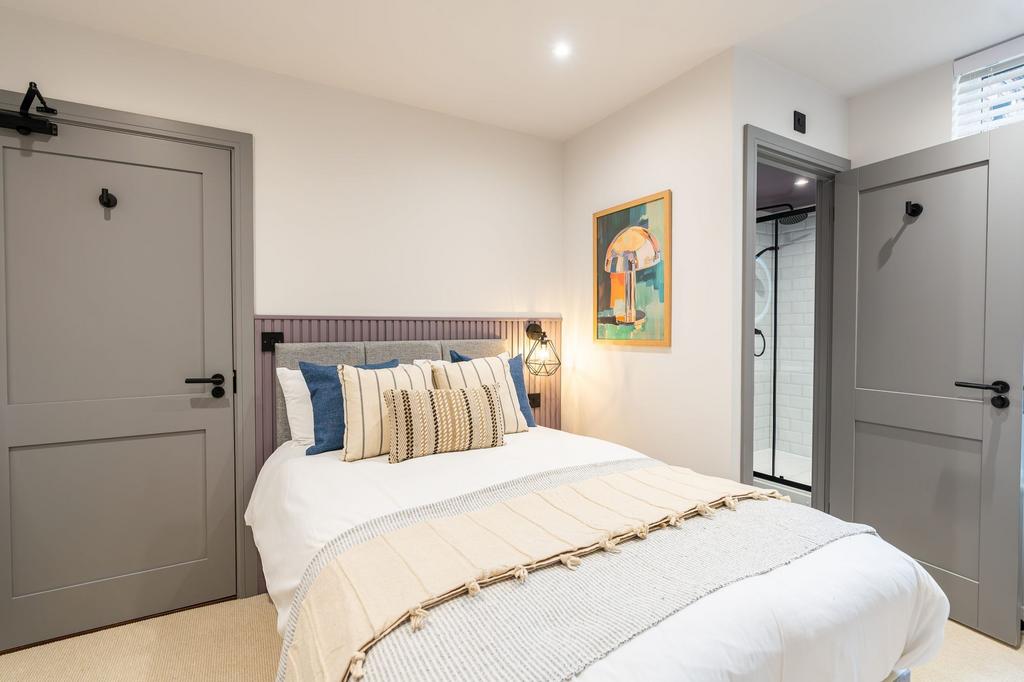 Bright and stylish master bedroom featuring a c...